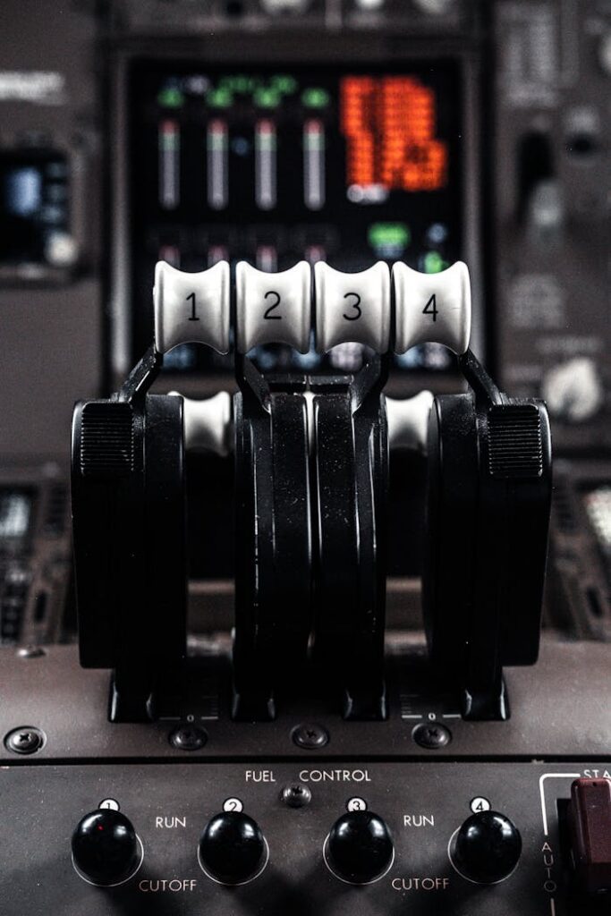 Detailed view of aircraft throttle levers in a cockpit, showing controls and indicators.